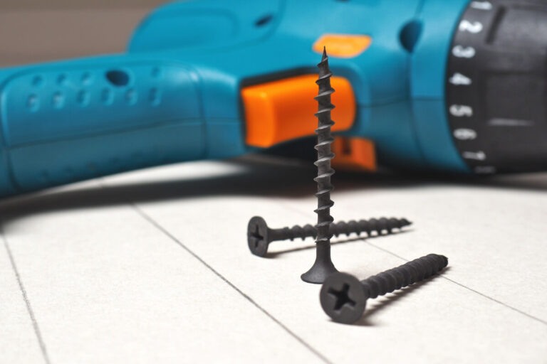 Drywall screws in front of an electric drill - Comprehensive Guide to Drywall Screws for Wholesalers and Construction Suppliers
