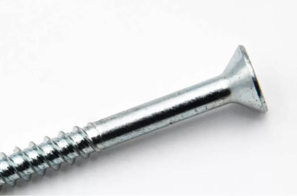 closeup image of the head and shaft of a screw that has been treated with zinc nickel alloy coating