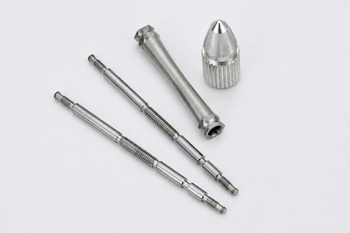 Custom CNC machined stainless steel stepped shafts with threaded ends, a socketed taper component, and a knurled cap